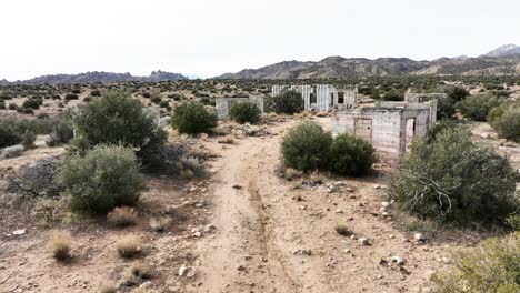 Verlassenes-Gebäude,-Betonstruktur,-Zerstört-Durch-Das-Kartell-In-Der-Hochwüste-Im-Süden-Kaliforniens-An-Einem-Bewölkten-Tag-Mit-Einer-Apokalyptischen-Stimmung,-Luftaufnahme-Mit-60-Bildern-Pro-Sekunde