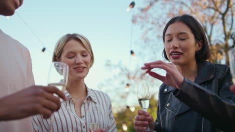 happy woman saying toast at birthday party closeup. friends cheering champagne