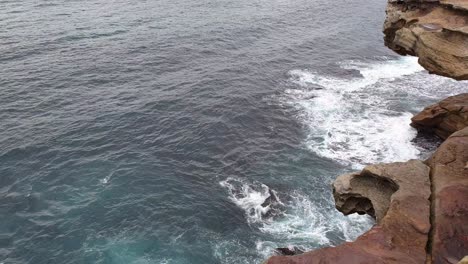 Blaue-Wellen,-Die-Auf-Einer-Felsigen-Klippe-In-Bronte-Beach,-Australien,-Zusammenbrechen---Während-Des-Coronavirus-Geschlossen