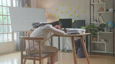 una mujer cansada durmiendo en su escritorio.