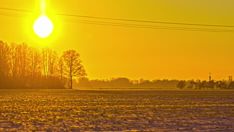 bright yellow sun setting down behind rural field, fusion time lapse view