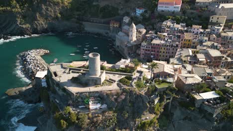 Cinematic-Drone-Shot-Above-Vernazza,-Cinque-Terre-as-Coastal-Train-Passes