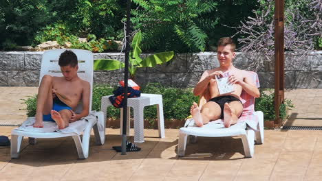 personas sentadas a la orilla de la piscina de un resort durante las vacaciones de verano
