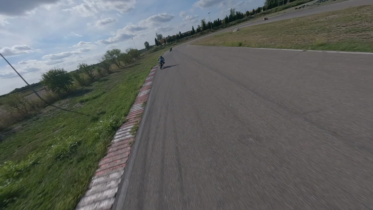 경마장 무릎 주변에서 경주 오토바이를 쫓는 빠른 fpv 드론 pov, 조감도