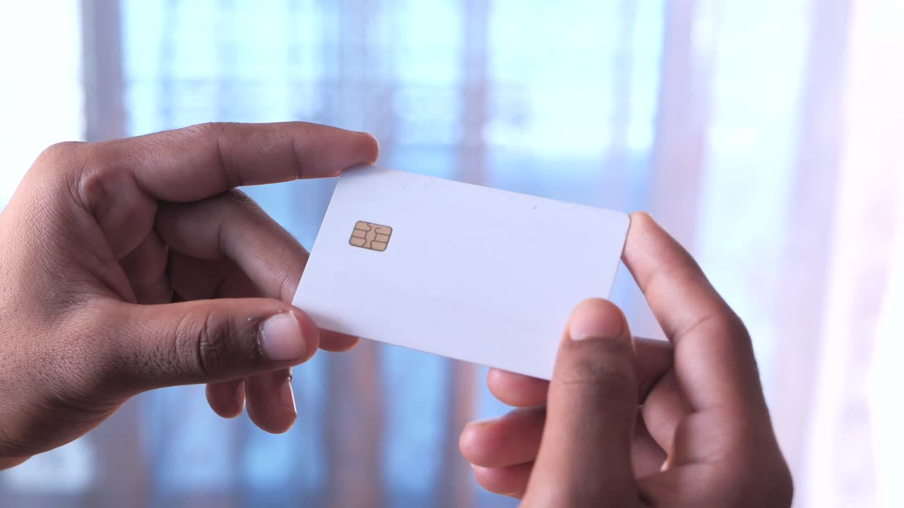 persona con una tarjeta sim o tarjeta de crédito blanca en blanco