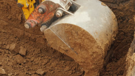 el cucharón de una poderosa excavadora elimina el suelo del pozo coloca la tubería