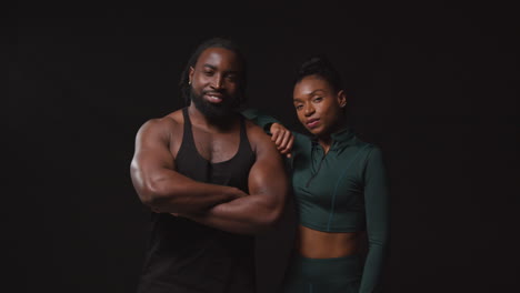 Studio-Portrait-Of-Smiling-Athletic-Couple-Or-Friends-In-Fitness-Clothing-Training-Shot-Against-Black-Background-2