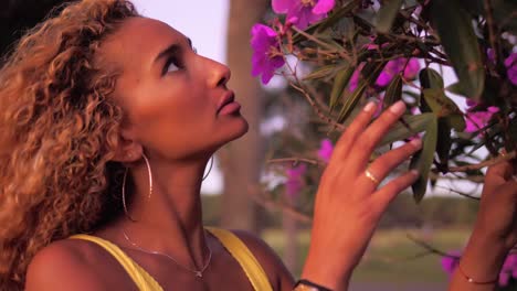 mujer sola en el parque oliendo el hermoso aroma de las flores violetas de centradenia - toma de primer plano