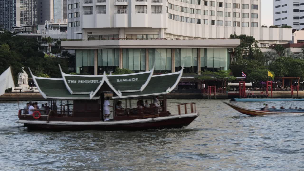 전통적인 배가 도시의 강을 가로질러 이동합니다.