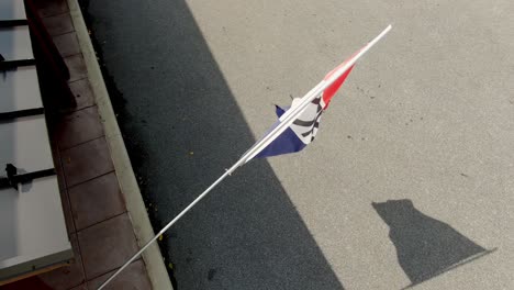 Aerial-top-down-view-of-OPEN-flag-waving-in-summer-breeze-with-shadow