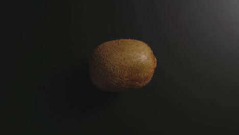 kiwi rotates on a black surface. top view. stop motion