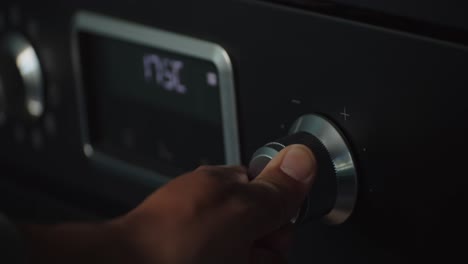 hand adjusting temperature of air conditioner by turning knob