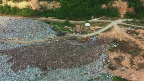 aerial birds eye view drone flyover and around a landfill site with unsorted wastes, showcasing environmental sustainability, microplastics and causes of global warming and climate change