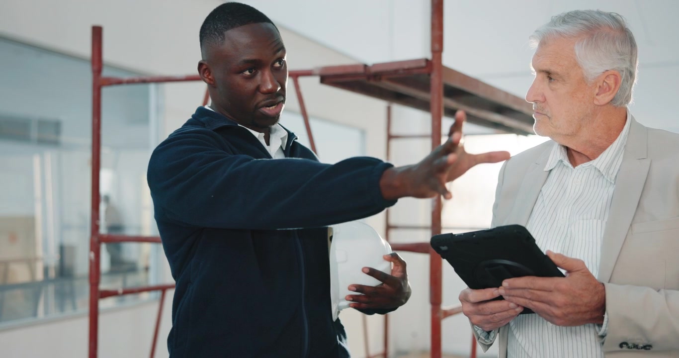 Construction Manager and Architect Discussing Project Plans on Tablet