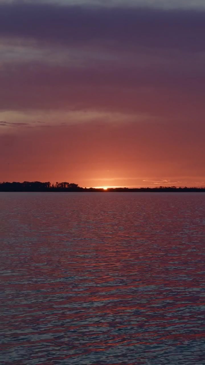 Dramatic Evening Sky Over River
Orange and purple sunset colors illuminate dramatic clouds above a wide peaceful river in Russia.