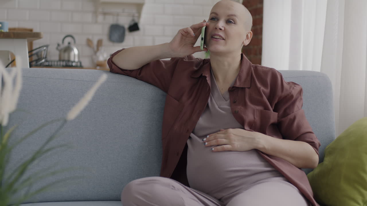 임신 한 여자 가 집 에서 전화 를 하고 있다