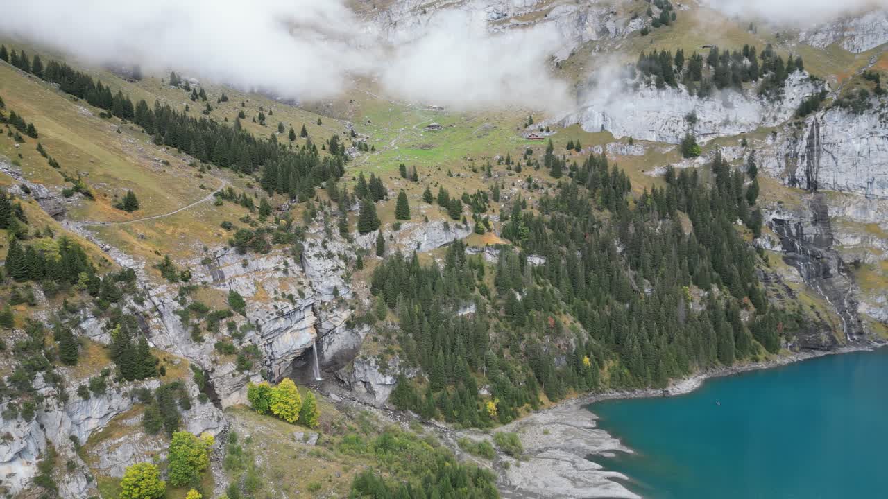 Riprese con drone dell'Öschinensee vicino a Kandersteg in Svizzera, con acqua turchese in direzione dell'imponente parete montuosa