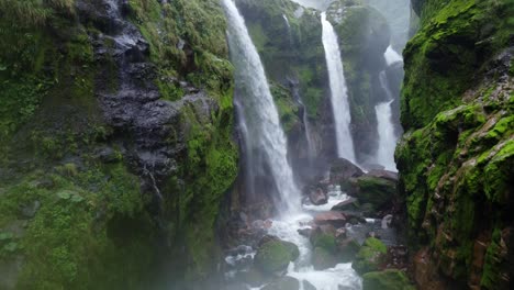 a breathtaking view of a man in the quebrada gata waterfalls in costa rica, showcasing multiple powerful cascades plunging into a rocky riverbed