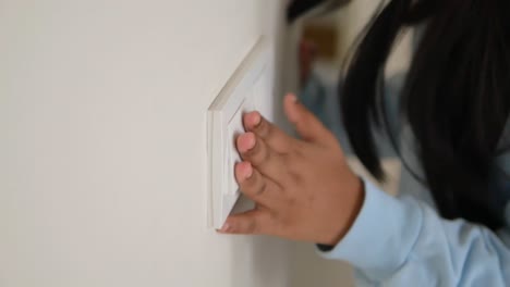 child turning on light switch