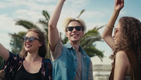 Young-caucasian-friends-dancing-on-music-festival-with-hands-up.