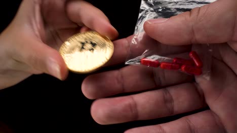 wide-angle macro view of bitcoin cryptocurrency being used to buy black market drugs, a small transparent bag with red pills on black background 4k