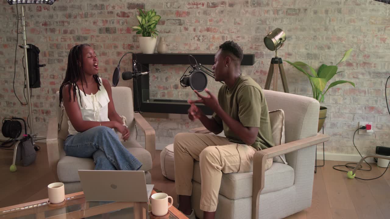Afroamerikanske verter sitter i et studio, der en kvinne starter diskusjonen og snakker mot en bommikrofon.