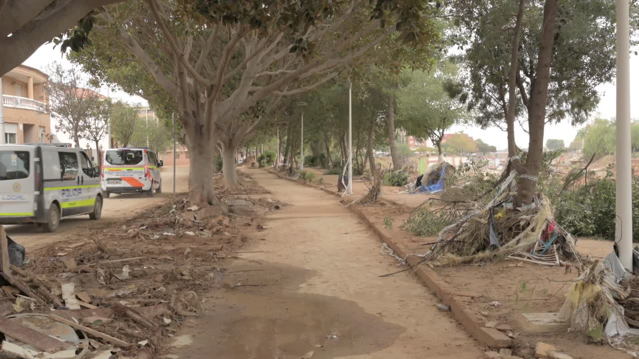 Paseo de Picaña with debris, mud, and emergency vehicles after DANA flooding