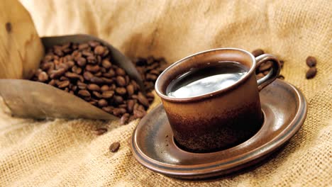 Black-coffee,-roasted-beans-and-scoop-on-sack