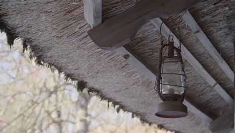 50 fps ancient old lantern hangs on a moss roof on a bright spring day