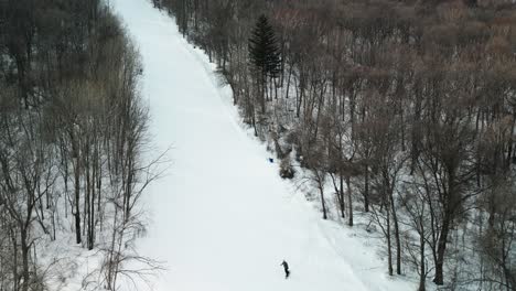 Vista-Aérea-Superior-Sobre-El-Snowboarder-Masculino-Slalom-Desde-La-Pendiente-Bkack-En-El-Resort-Yabuli-Cerca-De-Harbin