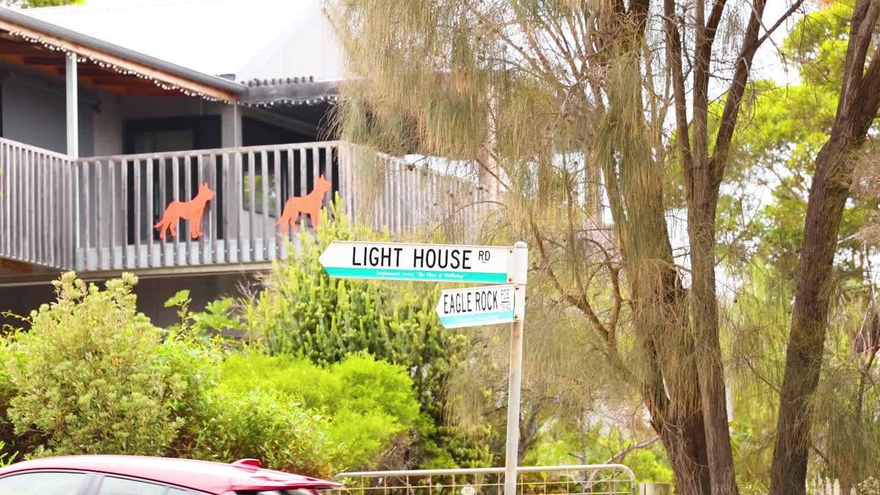 A series of frames showing a lighthouse sign amidst lush greenery along the Great Ocean Road, Australia