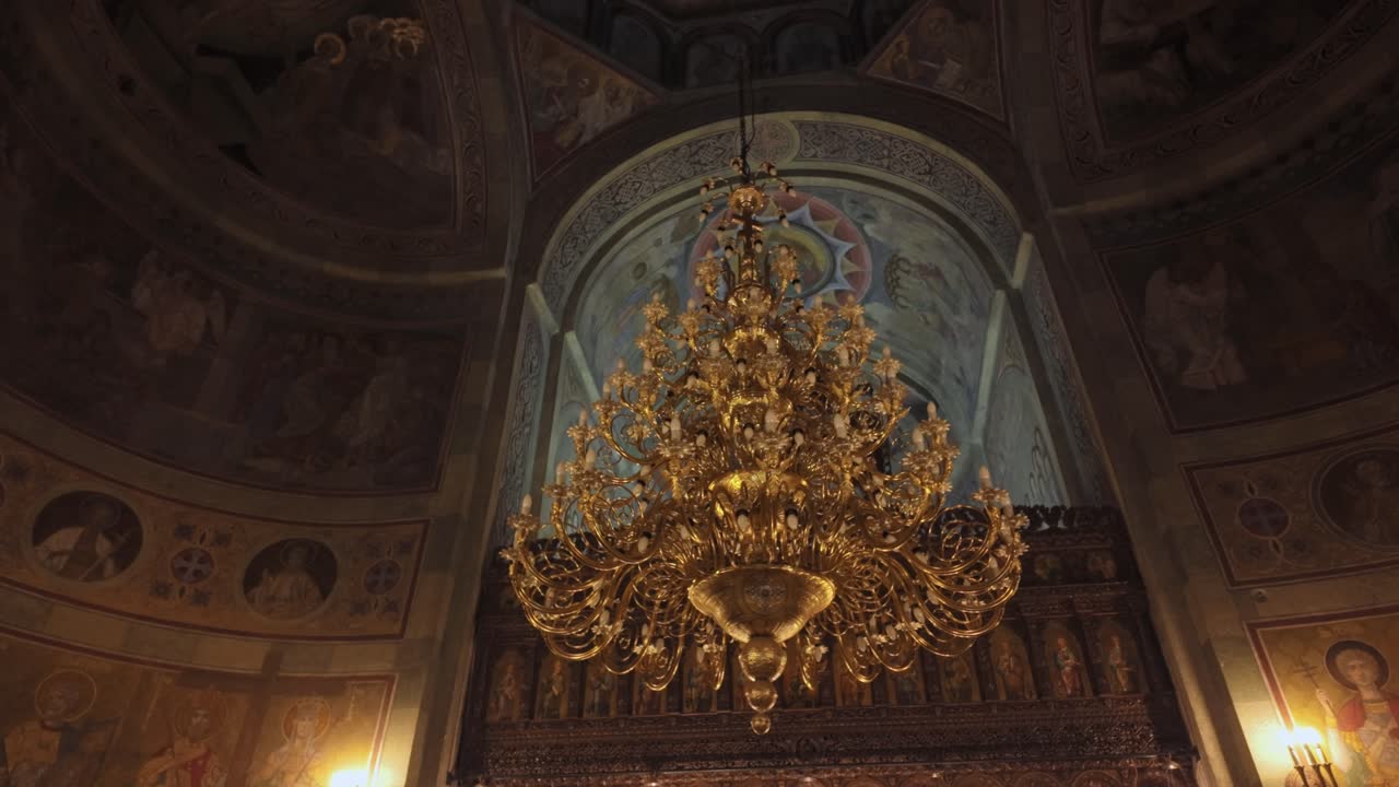 Ornate chandelier beneath frescoed dome in Mihai Vodă Church Bucharest