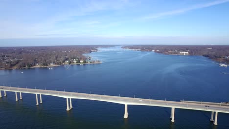 wide and high shot of two bridges spanning a vast river below on a clear blue winter day