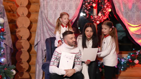 look at this. little girls showing their handmade pictures while spending time at home with their parents. children waiting for the santa