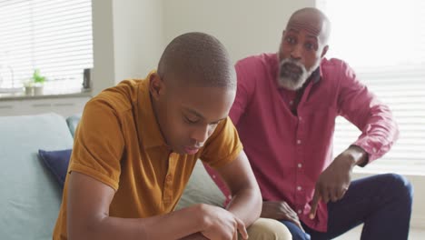 Video of nervous african american father yelling on son at home