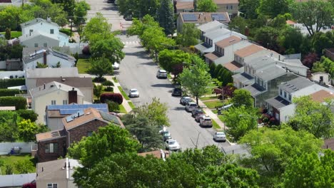 aerial panorama view showing parking cars in american residential area with green trees at sunny day - zoom lens drone shot