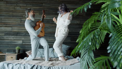couple dancing on bed with guitar