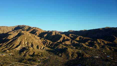 Drone-shot-panning-left-across-mountains-and-desert-in-California