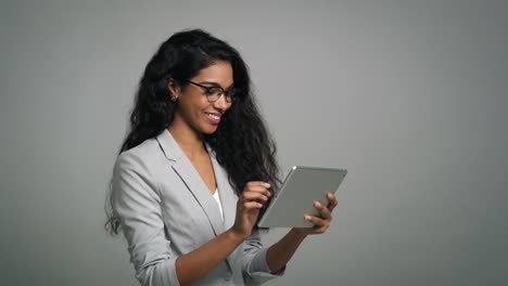 una joven mujer de negocios sonriente usa una mesa digital en una toma de estudio