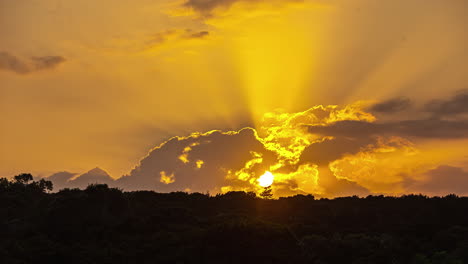 Zeitrafferaufnahme-Des-Sonnenuntergangs-Durch-Weiße-Wolken-über-Einem-Ruhigen-Nadelwald-Am-Abend