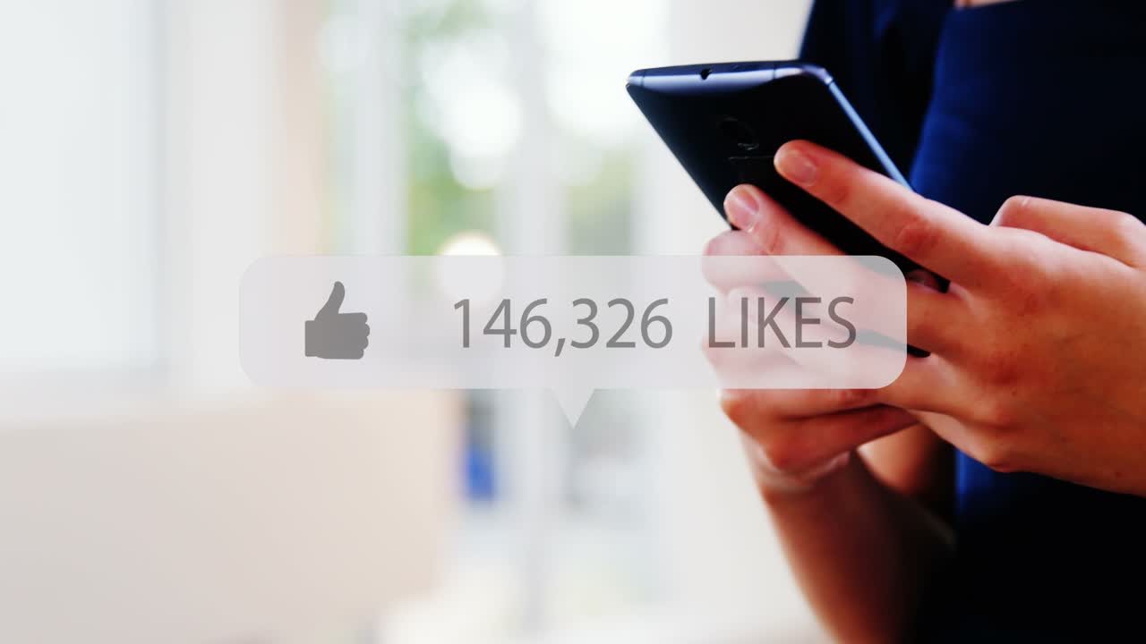 Animation of media icon over hands using smartphone