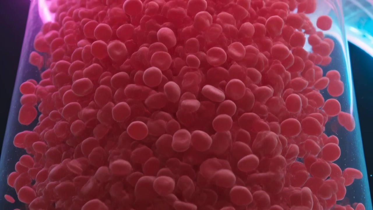 Starting clear tube showing pink pellets shifting, rising in dim exhibit, purple-cyan glow