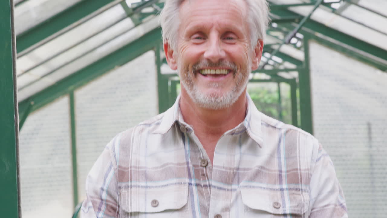 retrato de un hombre mayor orgulloso y sonriente sosteniendo una caja de verduras cultivadas en casa en un invernadero