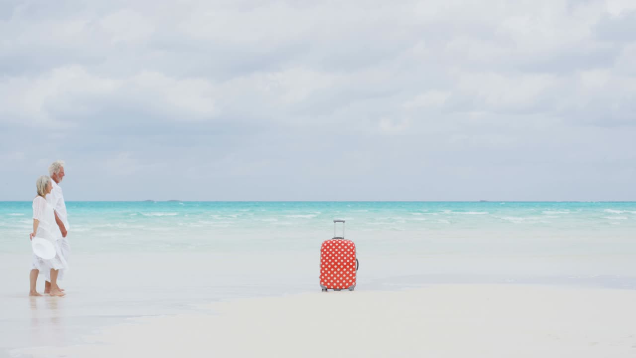 백인 노인 여행자 들 이 가방 을 들고 해변 에 나가고 있다