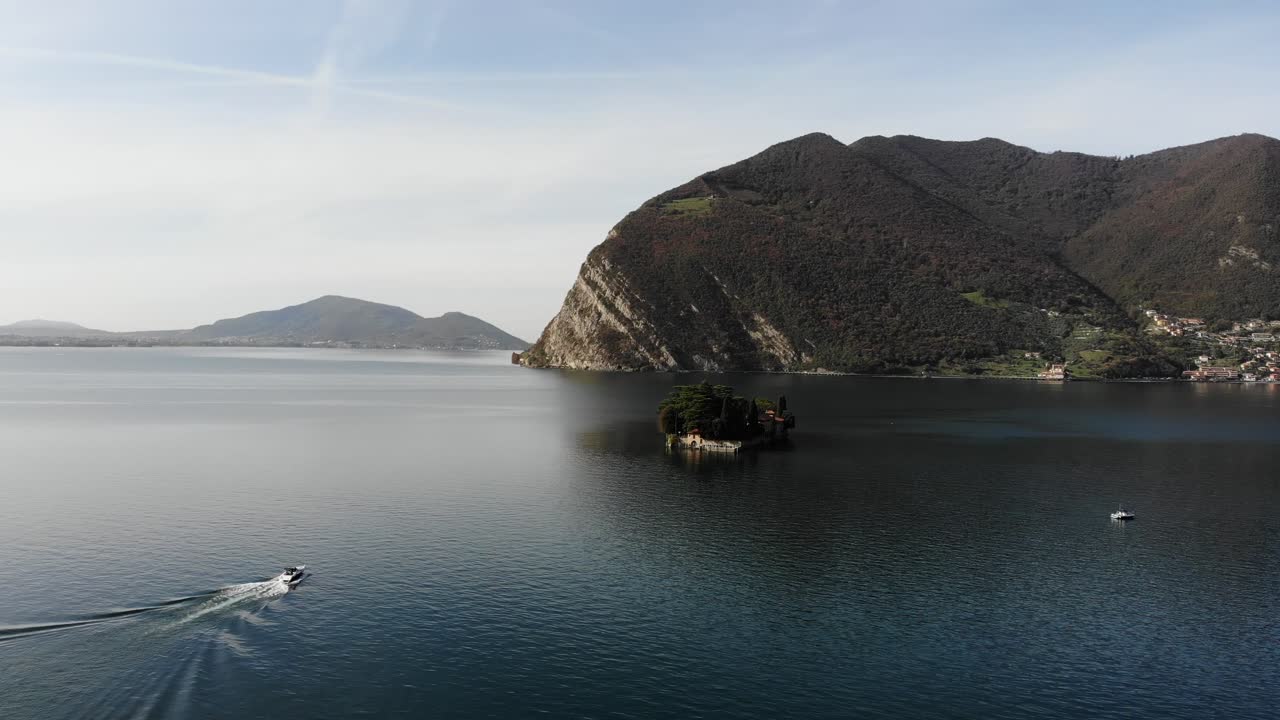 Drone follows boat approaching to San Paolo island on Iseo lake