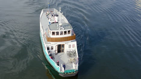 Old-ferry-cruise-ship-boat-floating-forwards-on-water-canal-in-Stockholm-Sweden-transportation-passenger-sail-shipping-vessel-marina-sea-goods-easy-low-consuming-carbon-dioxide-horn-captain-vintage