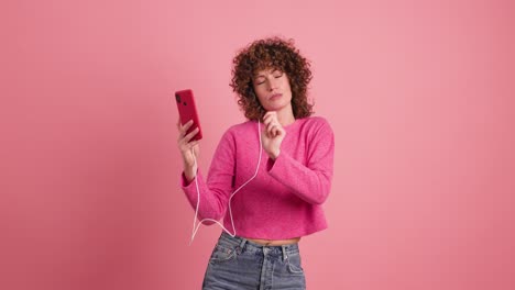 woman dancing and listening to music with smartphone in studio