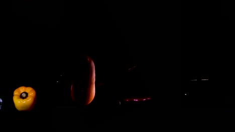 mixed veggies dropping down against a black background
