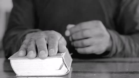 orando a dios con las manos en la biblia en la mesa con la gente stock footage stock video