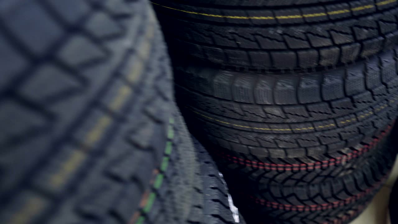 muchos neumáticos de invierno nuevos en los estantes y en las columnas. panorama de la tienda.